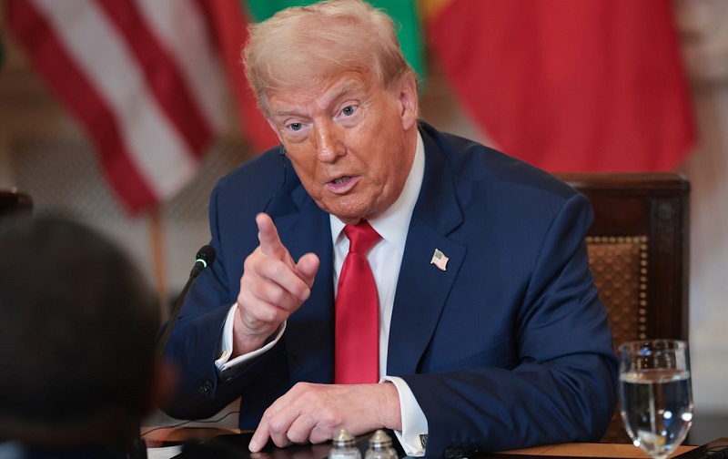 Trump sitting and pointing